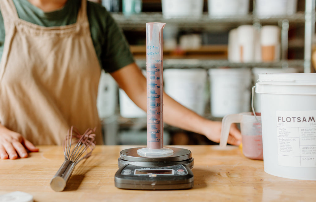 Graduated cylinder on a scale with whisk