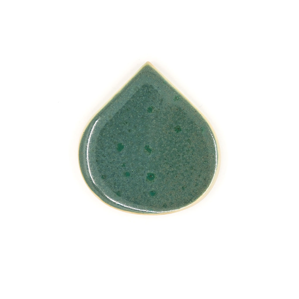 Green ceramic teardrop-shaped object on a white background