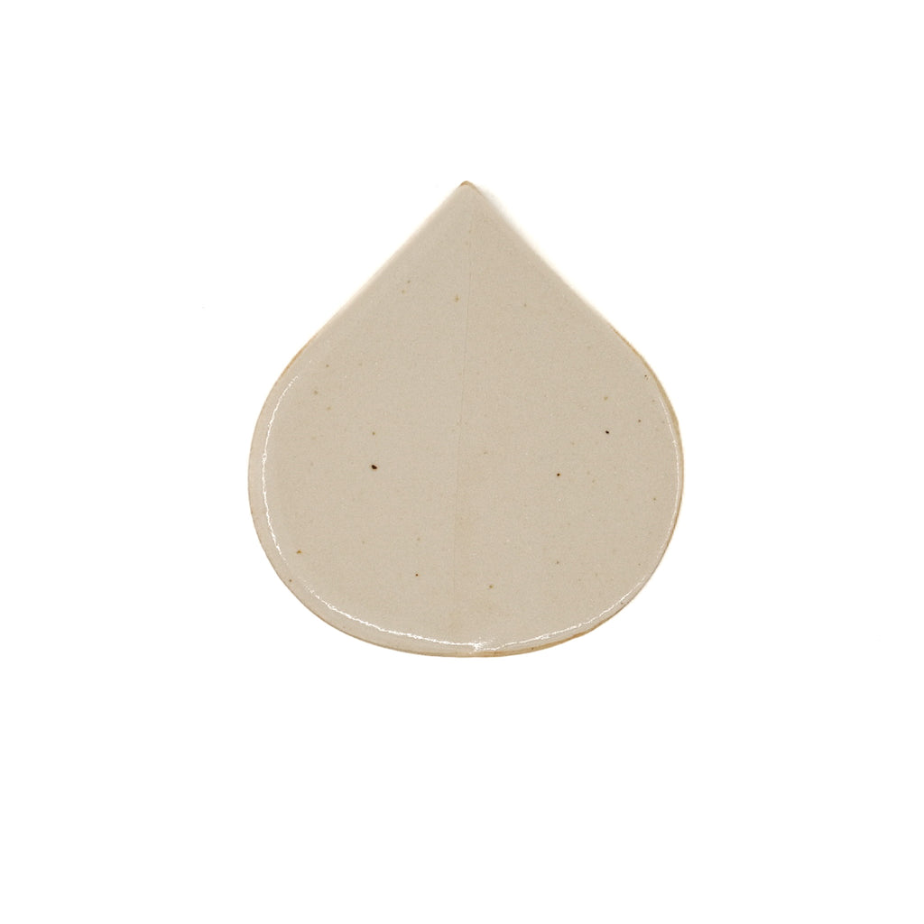 tear drop shaped off white tile on white background